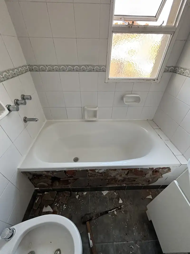 Baño con bañera y bidet antes de la reforma de la instalación sanitaria