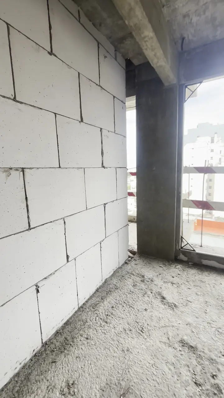 Columna de hormigón armado y pared nueva de bloques en un edificio en construcción