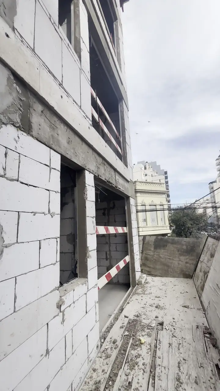 Edificio de varios pisos en obra gris con estructura de hormigón y paredes de bloques