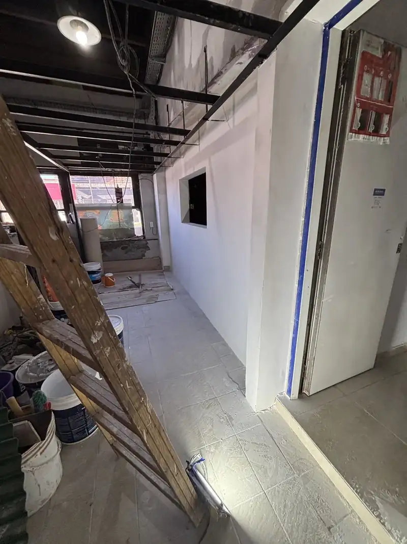 Local en obra con un tabique de durlock nuevo, cielorraso abierto y luz colgante